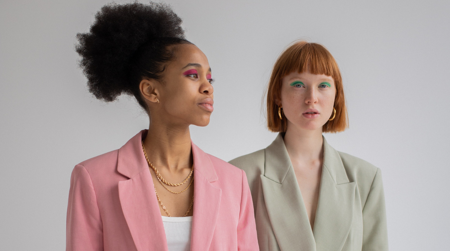 Two fashion models wearing jewelry in a studio editorial.